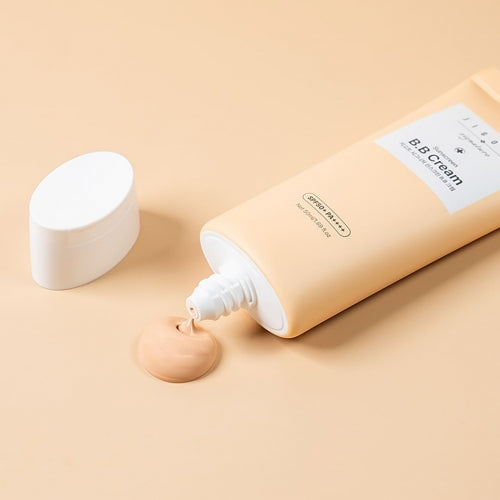 Jigott BB Cream Sunscreen tube with cap off and product cream squeezed out on beige background